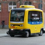 Masina autonoma de culoare galbena pe o strada publica.