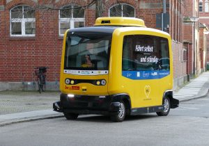 Masina autonoma de culoare galbena pe o strada publica.