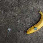 Ce înseamnă marca Fairtrade. Imagine a unei banane galbene pe un fundal gri si simbolul Fairtrade