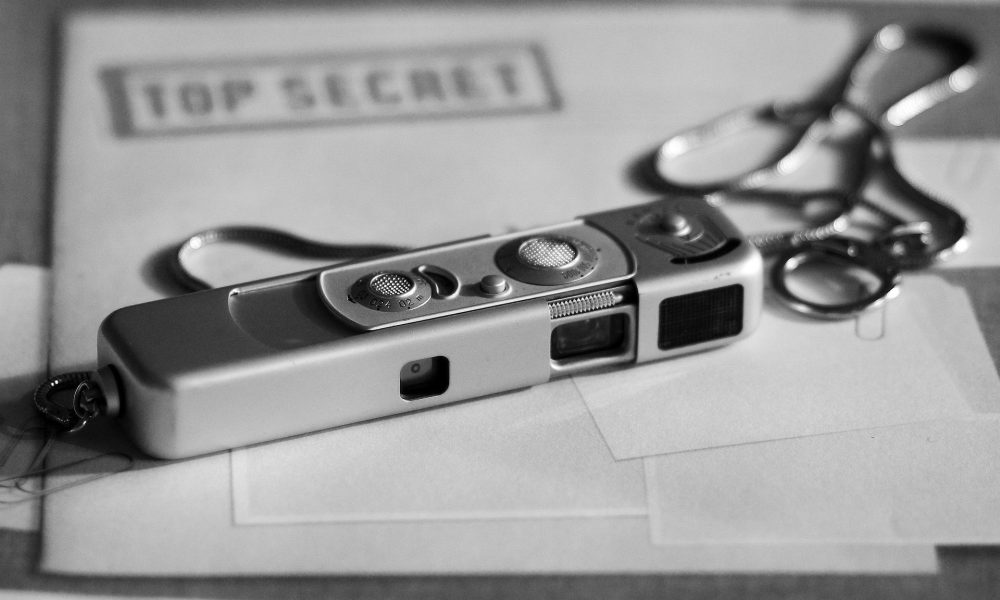 O imagine a unui aparat miniatural foto asezat penste un dosar strict secret