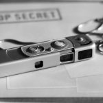 O imagine a unui aparat miniatural foto asezat penste un dosar strict secret