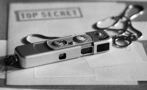 O imagine a unui aparat miniatural foto asezat penste un dosar strict secret