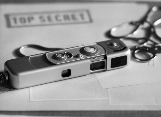 O imagine a unui aparat miniatural foto asezat penste un dosar strict secret