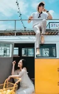 Lifestyle blog doi tineri care stau pe o masina de culoare galbena.