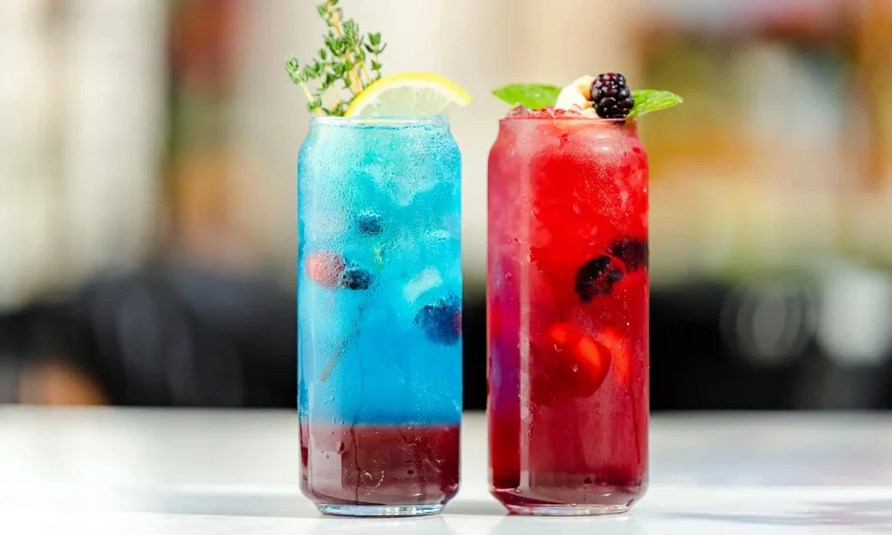 Douc mocktailuri asezate pe o masa unul albastru si unul rosu