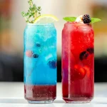Douc mocktailuri asezate pe o masa unul albastru si unul rosu