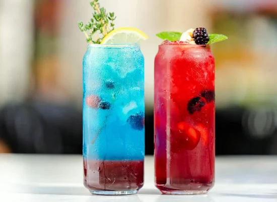 Douc mocktailuri asezate pe o masa unul albastru si unul rosu